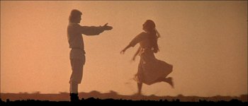 Movie still from “Fiddler on the Roof” (1971), directed by Norman Jewison – A man and a woman are running in the desert; Wide shot, Low angle