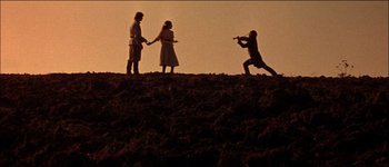 Movie still from “Fiddler on the Roof” (1971), directed by Norman Jewison – A group of people standing on top of a dirt hill; Wide shot, Low angle