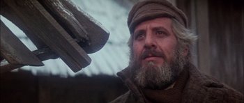 Movie still from “Fiddler on the Roof” (1971), directed by Norman Jewison – An old man with a beard and a hat is looking at the camera; Close Up shot, Low angle