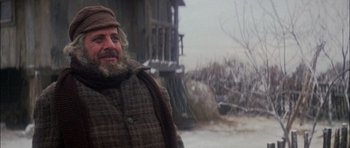 Movie still from “Fiddler on the Roof” (1971), directed by Norman Jewison – A man with a long beard standing in front of a building; Medium shot, Low angle
