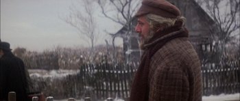 Movie still from “Fiddler on the Roof” (1971), directed by Norman Jewison – An older man wearing a scarf and a hat looking out a fence; Close Up shot, Over the shoulder angle