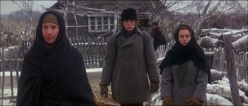Movie still from “Fiddler on the Roof” (1971), directed by Norman Jewison – A woman in a hat and coat walking down a street; Medium shot, Low angle
