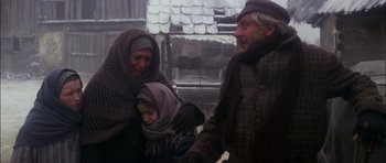 Movie still from “Fiddler on the Roof” (1971), directed by Norman Jewison – An older man and woman holding hands with a young girl; Medium shot, Low angle