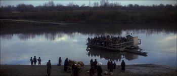 Movie still from “Fiddler on the Roof” (1971), directed by Norman Jewison – A group of people on a boat on a body of water; Extreme Wide shot, High angle