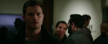 Movie still from “Fifty Shades Darker” (2017), directed by James Foley – A group of people standing next to each other in a room; Close Up shot, Over the shoulder angle