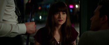 Movie still from “Fifty Shades Darker” (2017), directed by James Foley – A woman with long brown hair holding a glass of wine; Close Up shot, Over the shoulder angle