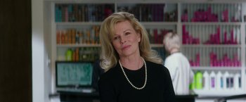 Movie still from “Fifty Shades Darker” (2017), directed by James Foley – A woman with blonde hair wearing a black shirt and pearls; Close Up shot, Over the shoulder angle