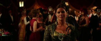 Movie still from “Fifty Shades Darker” (2017), directed by James Foley – A woman in a green and gold dress at an event; Close Up shot, Over the shoulder angle