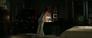 Movie still from “Fifty Shades Darker” (2017), directed by James Foley – A woman standing in front of a desk in a dark room; Wide shot, High angle