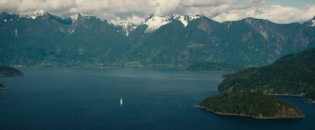 Movie still from “Fifty Shades Darker” (2017), directed by James Foley – A sailboat sailing on a large body of water near mountains; Extreme Wide shot, High angle