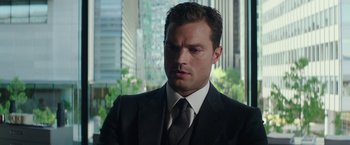 Movie still from “Fifty Shades Darker” (2017), directed by James Foley – A person wearing a suit and tie; Close Up shot, Over the shoulder angle