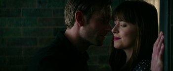 Movie still from “Fifty Shades Darker” (2017), directed by James Foley – A man and a woman face to face in a dark room; Close Up shot, Over the shoulder angle