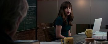 Movie still from “Fifty Shades Darker” (2017), directed by James Foley – A woman sitting at a table with a coffee mug; Medium shot, Over the shoulder angle