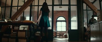 Movie still from “Fifty Shades Darker” (2017), directed by James Foley – A woman in a green dress standing in front of a window; Wide shot, Low angle