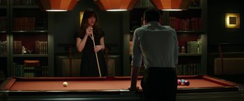 Movie still from “Fifty Shades Darker” (2017), directed by James Foley – A man and a woman playing a game of billiards; Medium shot, Over the shoulder angle