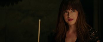 Movie still from “Fifty Shades Darker” (2017), directed by James Foley – A beautiful young lady standing in front of a pool cue; Close Up shot, Over the shoulder angle