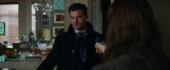 Movie still from “Fifty Shades Darker” (2017), directed by James Foley – A man wearing a black coat and a tie; Close Up shot, Over the shoulder angle