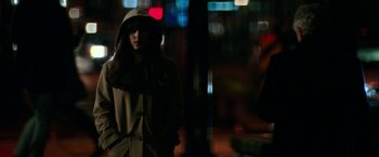 Movie still from “Fifty Shades Darker” (2017), directed by James Foley – A woman wearing a hooded jacket standing on a street; Medium shot, Over the shoulder angle