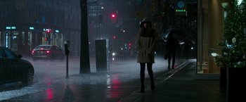 Movie still from “Fifty Shades Darker” (2017), directed by James Foley – A woman walking down the street in the rain at night; Wide shot, High angle