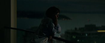 Movie still from “Fifty Shades Darker” (2017), directed by James Foley – A woman leaning on a railing at night; Medium shot, High angle