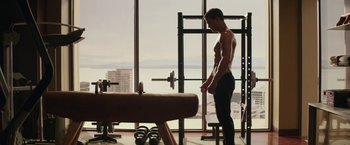 Movie still from “Fifty Shades Darker” (2017), directed by James Foley – A man standing in a gym next to a window; Wide shot, Over the shoulder angle