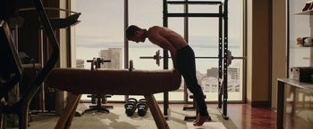 Movie still from “Fifty Shades Darker” (2017), directed by James Foley – A man is bending over a bench in a gym; Medium shot, Low angle