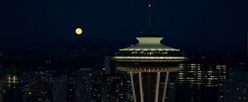 Movie still from “Fifty Shades Darker” (2017), directed by James Foley – A full moon setting over a city at night; Extreme Wide shot, High angle