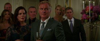 Movie still from “Fifty Shades Darker” (2017), directed by James Foley – A man in a suit and tie holding a glass of wine; Close Up shot, Over the shoulder angle