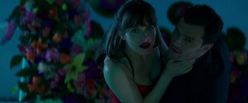 Movie still from “Fifty Shades Darker” (2017), directed by James Foley – A beautiful young lady posing for a picture; Close Up shot, Over the shoulder angle