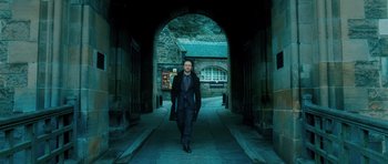 Movie still from “Filth” (2013), directed by Jon S. Baird – A man in a suit and tie walking down a street; Wide shot, Low angle