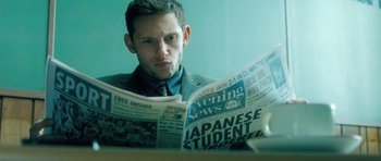 Movie still from “Filth” (2013), directed by Jon S. Baird – A man sitting in front of a mirror reading a newspaper; Close Up shot, Low angle