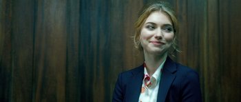 Movie still from “Filth” (2013), directed by Jon S. Baird – A woman in a suit and tie smiling for the camera; Close Up shot, Over the shoulder angle