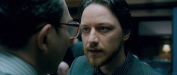 Movie still from “Filth” (2013), directed by Jon S. Baird – A person with a beard and glasses; Close Up shot, Over the shoulder angle