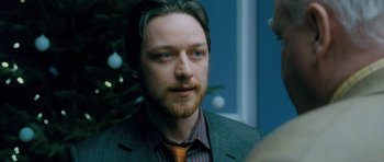 Movie still from “Filth” (2013), directed by Jon S. Baird – A person wearing a suit and tie; Close Up shot, Over the shoulder angle