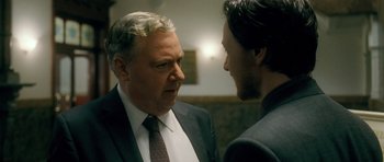 Movie still from “Filth” (2013), directed by Jon S. Baird – A man in a suit and tie talking to another man in a suit and tie; Close Up shot, Over the shoulder angle