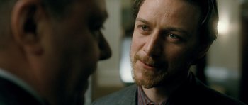 Movie still from “Filth” (2013), directed by Jon S. Baird – A person wearing a suit and a tie; Close Up shot, Over the shoulder angle