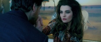 Movie still from “Filth” (2013), directed by Jon S. Baird – A man and a woman sitting next to each other in front of each other; Close Up shot, Over the shoulder angle