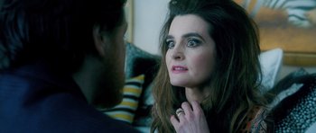 Movie still from “Filth” (2013), directed by Jon S. Baird – A woman looking into a mirror while standing next to a man; Close Up shot, Over the shoulder angle