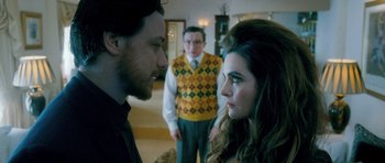 Movie still from “Filth” (2013), directed by Jon S. Baird – A man and a woman standing next to each other in a room; Medium shot, Over the shoulder angle