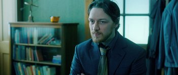 Movie still from “Filth” (2013), directed by Jon S. Baird – A person wearing a suit and a tie; Close Up shot, Over the shoulder angle