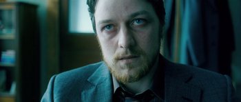 Movie still from “Filth” (2013), directed by Jon S. Baird – A person wearing a suit and tie; Close Up shot, High angle