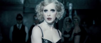 Movie still from “Filth” (2013), directed by Jon S. Baird – A woman in a black dress and a silver necklace; Close Up shot, Over the shoulder angle