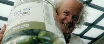 Movie still from “Filth” (2013), directed by Jon S. Baird – An older man holding a jar of green apples; Extreme Close Up shot, Low angle
