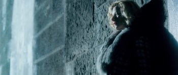 Movie still from “Filth” (2013), directed by Jon S. Baird – A woman wearing a fur coat standing in front of a wall; Medium shot, Low angle