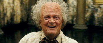 Movie still from “Filth” (2013), directed by Jon S. Baird – An old man with a white wig and a beard; Close Up shot, Low angle