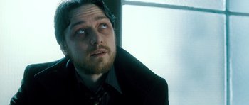 Movie still from “Filth” (2013), directed by Jon S. Baird – A person wearing a suit and tie; Close Up shot, Low angle