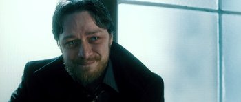 Movie still from “Filth” (2013), directed by Jon S. Baird – A person wearing a suit and tie; Close Up shot, Low angle