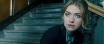 Movie still from “Filth” (2013), directed by Jon S. Baird – A beautiful young lady sitting in front of a staircase; Close Up shot, Over the shoulder angle