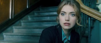 Movie still from “Filth” (2013), directed by Jon S. Baird – A person sitting on a set of stairs; Close Up shot, Over the shoulder angle