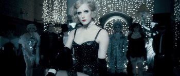 Movie still from “Filth” (2013), directed by Jon S. Baird – A woman in a black dress in front of a mirror; Medium shot, Over the shoulder angle